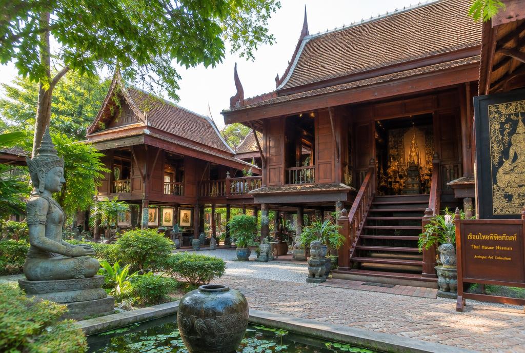 Maison traditionnelle thaïe en teck entourée d'un jardin tropical