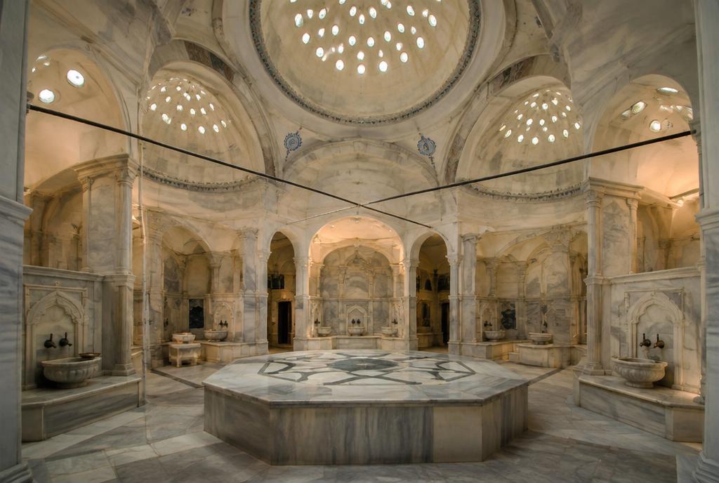 Salle de marbre d'un hammam ottoman sous une coupole percée