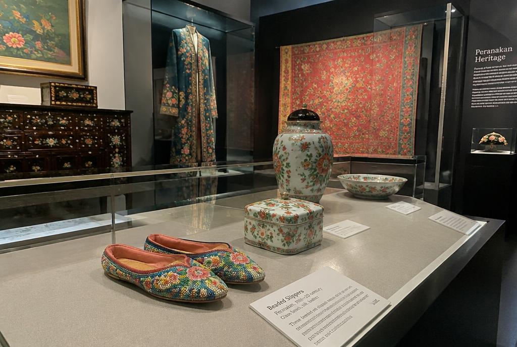 Vitrine de textiles et porcelaines peranakan dans un musée de Singapour